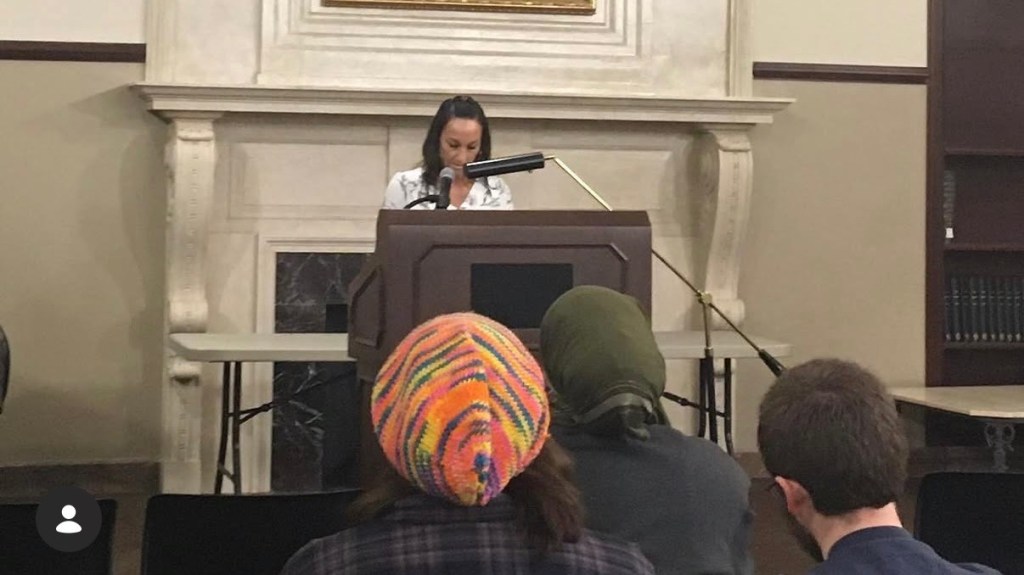 Jamir reads at a podium on the OSU campus in Stillwater, OK